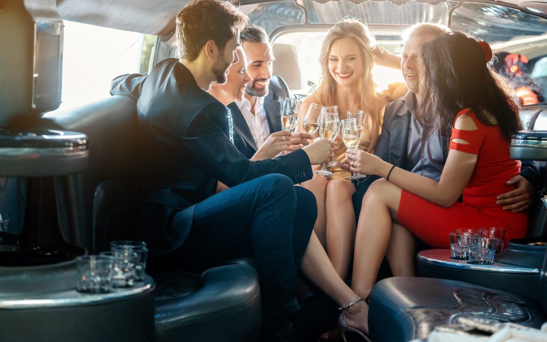 People in formal attire are celebrating and enjoying drinks inside a luxury limousine, thanks to an exceptional limo rental service.